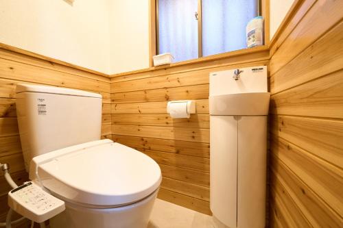 a wooden bathroom with a toilet and a window at 花の宿 別府 in Beppu