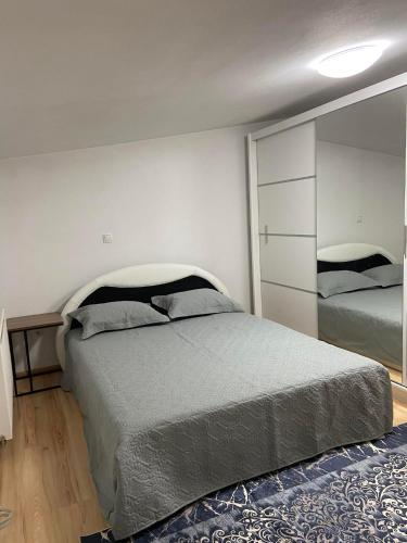 a bedroom with a large bed and a mirror at Stan Na Dan Pehlić - Apartments For The Day Cazin in Cazin
