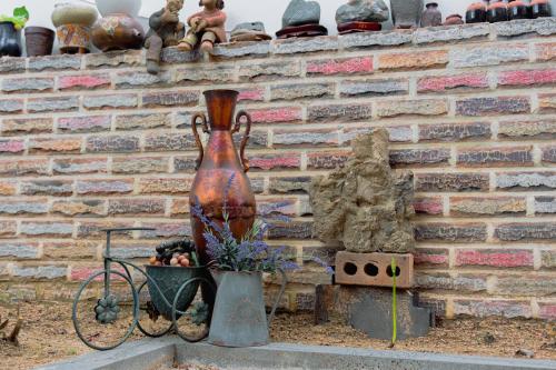 a large vase sitting next to a brick wall at Beautiful Garden Fine Day House in Jeonju