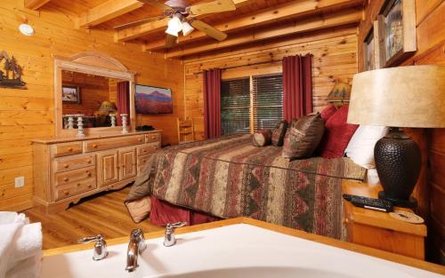 a bedroom in a log cabin with a bed and a sink at Bear Retreat in Pigeon Forge