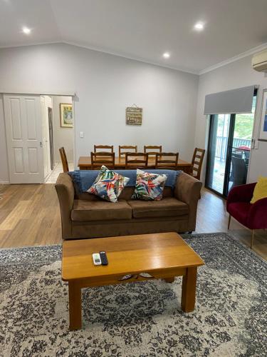 a living room with a couch and a coffee table at Koala Cabins Sunshine Coast in Mapleton