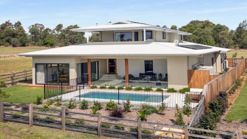 a house with a swimming pool in front of it at Pirama - The Vintage Holiday Houses in Pokolbin