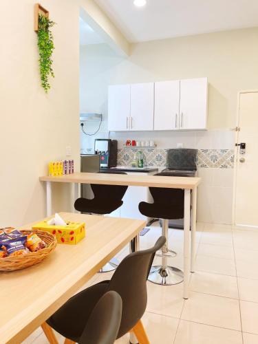 a kitchen with white cabinets and a table and chairs at The Floral Dawn Anderson in Kampong Simee