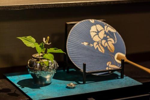 a chair sitting on a table with a plant in a vase at すみや 青花 in Takayama