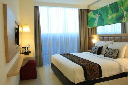 a hotel room with a bed and a large window at Hotel Agria Bogor in Muara