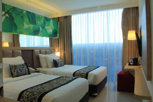a hotel room with two beds and a large window at Hotel Agria Bogor in Muara