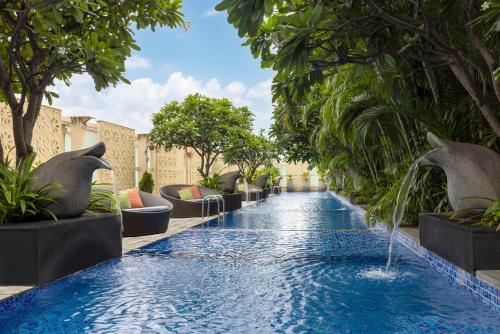 a swimming pool with a fountain in a resort at The Ritz-Carlton, Bangalore in Bengaluru