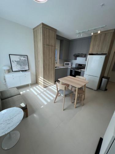 a living room with a table and a kitchen at Waverley Guest Room in Vancouver in Vancouver