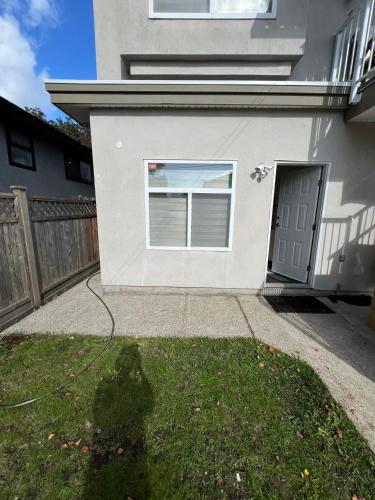 a white garage with a window and a fence at Waverley Guest Room in Vancouver in Vancouver