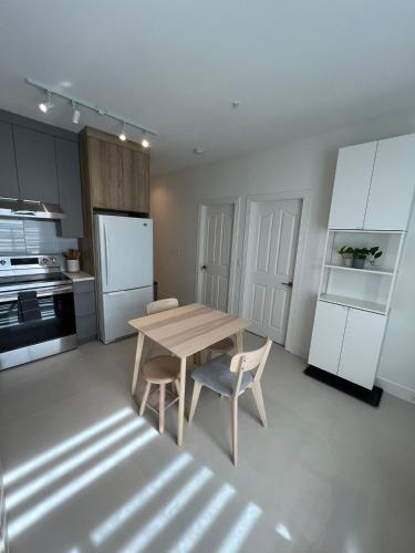 a kitchen with a wooden table and two chairs at Waverley Guest Room in Vancouver in Vancouver