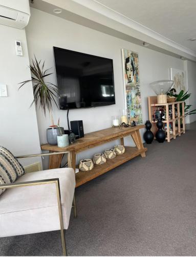 a living room with a flat screen tv on a wall at Burleigh View in Gold Coast