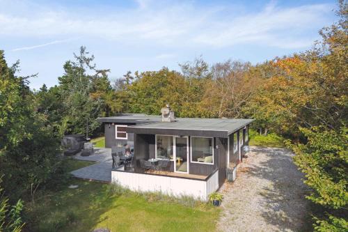 a small house in the middle of a forest at Enjoy A Holiday Just 200 M From Ringkøbing Fjord in Skjern