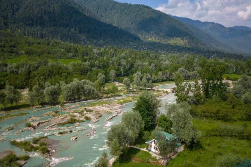 an aerial view of a river with mountains in the background at Water's Edge by VEO - Part of StayVista in Chak-i-Dāra