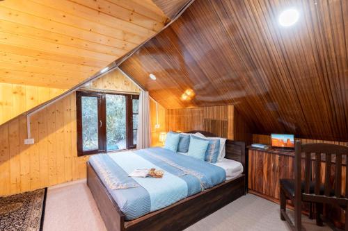 a bedroom with a bed in a wooden cabin at Water's Edge by VEO - Part of StayVista in Chak-i-Dāra