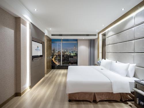 Postel nebo postele na pokoji v ubytování Suning Universal Hotel ALL-SUITES