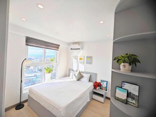 a bedroom with a large white bed and a window at Homestay newlife Hạ Long in Ha Long