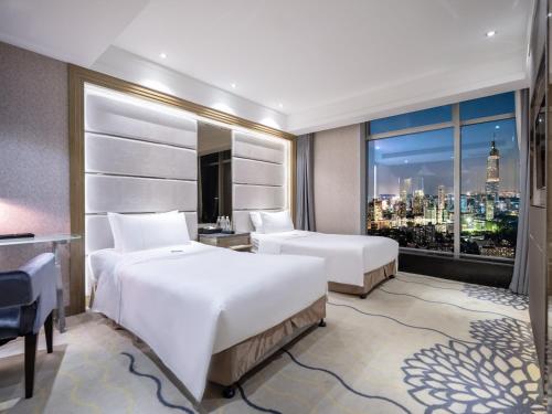 Postel nebo postele na pokoji v ubytování Suning Universal Hotel ALL-SUITES