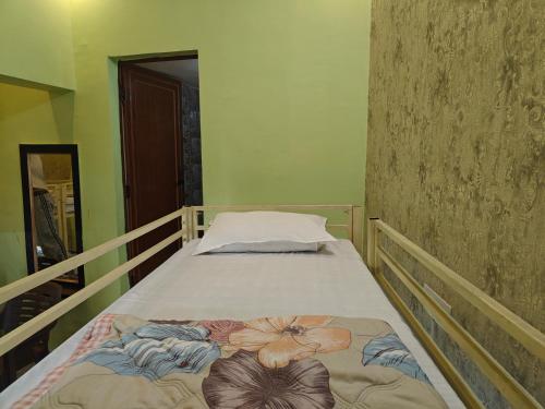 a small bedroom with a bed with a flower design on it at Shreeji Inn Homestay in Rishīkesh