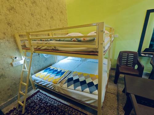 two bunk beds in a room with a desk at Shreeji Inn Homestay in Rishīkesh