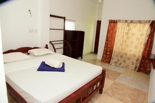 Un dormitorio con una cama con una toalla azul encima. en Athula Hikka beach Guesthouse, en Hikkaduwa