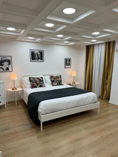 罗马COLONNA HOLIDAY HOME的一间卧室，有一张大床，两张桌子和两盏灯