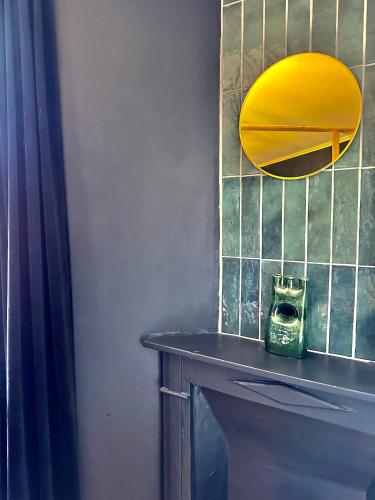 La salle de bains est pourvue d'un miroir jaune et d'un lavabo. dans l'établissement Confort - 4 pers - WIFI - plage à 400 m, à Berck-sur-Mer