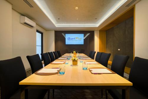 a conference room with a long wooden table with chairs at Quest Plus Conference Center, Clark in Clark