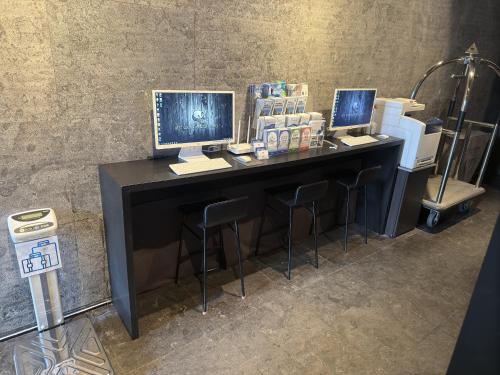 a desk with two monitors and two stools at Best Louis Hamilton Hotel Haeundae in Busan