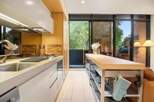 墨尔本Southside urban oasis的配有白色橱柜和台面的厨房