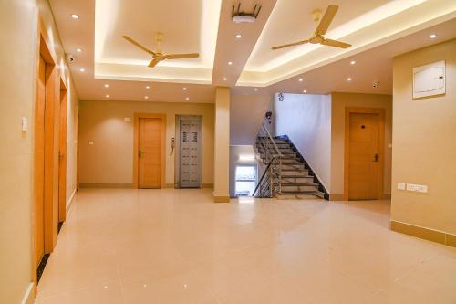 a hallway with two ceiling fans and a staircase at FabHotel JP - Nr Sataragachhi Railway Station in Hāora