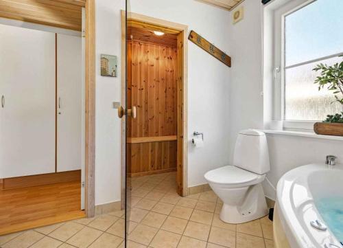 a bathroom with a toilet and a sink and a window at Summer House For Relaxation And Activity in Gråsten