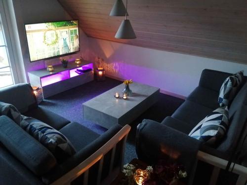a living room with couches and a table and purple lighting at Summer House For Relaxation And Activity in Gråsten