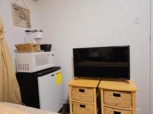 a tv sitting on top of a table with a microwave at Cozy Boho Room at the Heart of Vancouver! Private Parking, Self Check-in & just 4 mins to Metrotown! in Burnaby