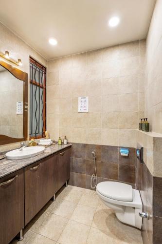 a bathroom with a toilet and a sink at ELIVAAS 5 BHK with Garden & Balconies - Lakeview Manor in Bhīm Tāl