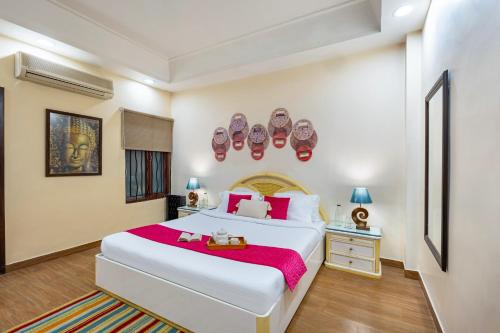 a bedroom with a large white bed with a red blanket at ELIVAAS 5 BHK with Garden & Balconies - Lakeview Manor in Bhīm Tāl