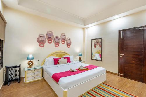 a bedroom with a large bed with a red blanket at ELIVAAS 5 BHK with Garden & Balconies - Lakeview Manor in Bhīm Tāl