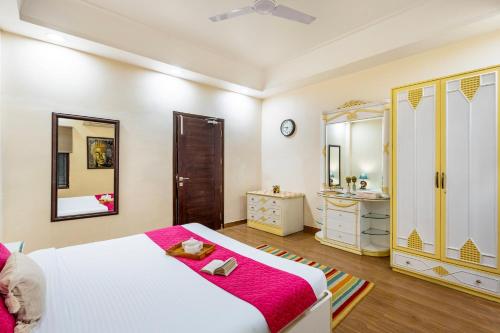 a bedroom with a bed and a sink and a mirror at ELIVAAS 5 BHK with Garden & Balconies - Lakeview Manor in Bhīm Tāl