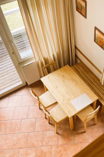 a wooden table and chairs in a room with a window at Tiny Houses & Schwedenhäuser Ahoi Camp Canow in Wustrow