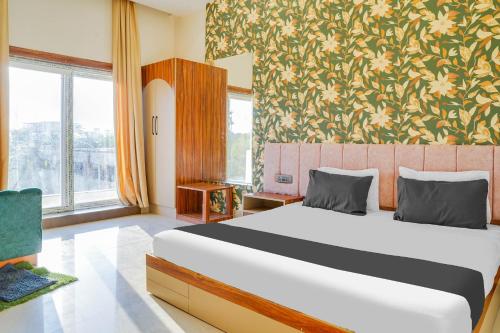 a bedroom with a bed and a floral wall at Hotel O Chouksey Farmstead in Bhopal
