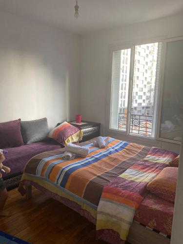 - une chambre avec un lit et un canapé avec une fenêtre dans l'établissement Appartement porte de paris, à Bourg-la-Reine
