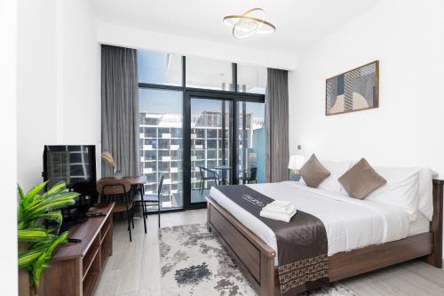 Escape24 Stylish Studio Azizi Riviera 8 Meydan one Dubai في دبي: غرفة نوم بها سرير ومكتب وشرفة