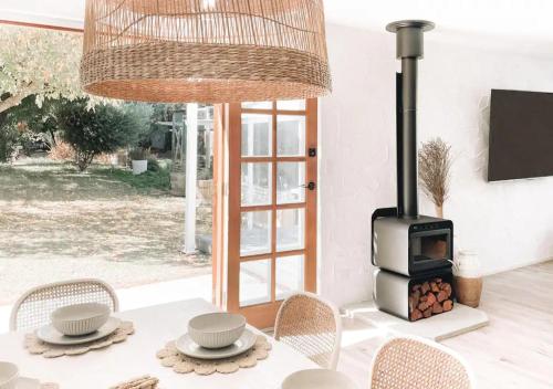 a dining table with a stove in a living room at Our NEW 1940's Lovingly Renovated Cosy Cottage in McLaren Vale