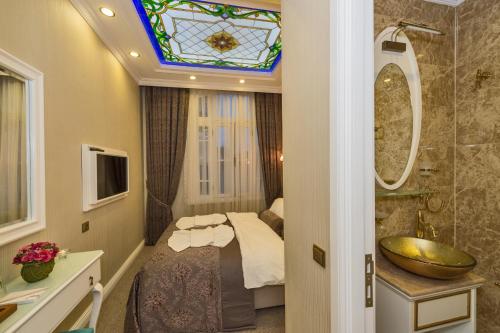 a bathroom with a bed and a sink and a mirror at Alpek Hotel in Istanbul