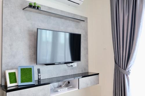 a flat screen tv hanging on a wall at KuchingCity - Snuggle - Sunset City View w Balcony in Kuching