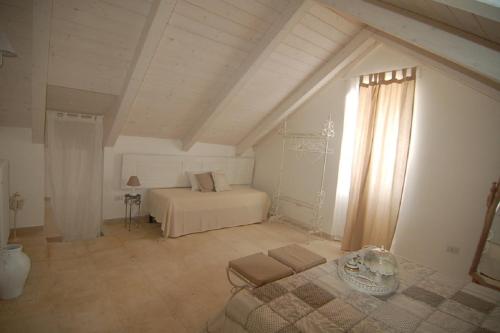 a white bedroom with a bed and a window at Domus Aurea in Martina Franca