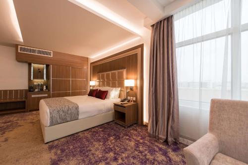 a hotel room with a bed and a window at Ramada by Wyndham Continental Jeddah in Jeddah