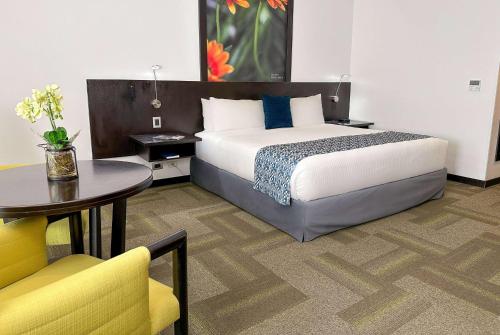 a hotel room with a bed and a table at Wyndham Quito Airport in Tababela