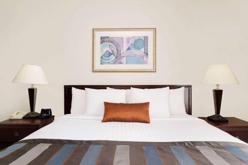 a bedroom with a large white bed with two lamps at Wingate by Wyndham Destin in Destin