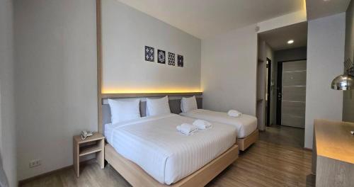 a bedroom with two beds with towels on them at Prom Hotel in Bangkok