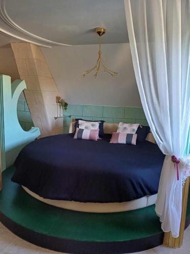 a bedroom with a large bed with a curtain at il piccolo castello in Méjannes-lès-Alès